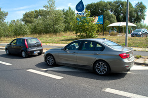 przy drodze stoi kontrolowany pojazd, a za nim policyjne bmw