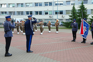 Komendant salutuje przed sztandarem.