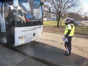 policjant kontroluje autokar przed komendą