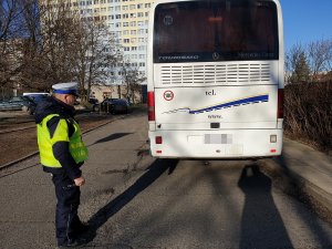 policjant kontroluje autokar przed komendą