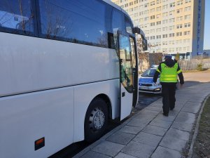 policjant kontroluje autokar przed komendą