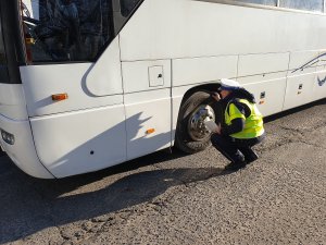 policjant kontroluje autokar przed komendą