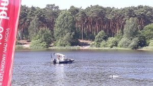 Zdjęcie przedstawia jez. Czarne, na którym służby odpowiedzialne za ratownictwo wodne przeprowadzili pokaz dla uczniów związany z bezpiecznymi wakacjami