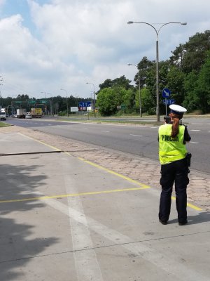 Policjantka podczas służby dokonująca kontroli prędkości przy wykorzystaniu ręcznego miernika.