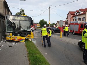 Zdjęcie pokazuje pracę policjantów na miejscu wypadku z udziałem samochodu osobowego i autobusu komunikacji miejskiej