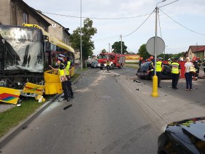 Zdjęcie pokazuje pracę policjantów na miejscu wypadku z udziałem samochodu osobowego i autobusu komunikacji miejskiej