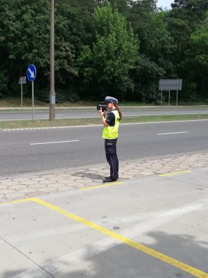 Zdjęcie pokazuje policjanta podczas mierzenia prędkości