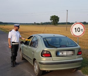 Policjant podczas wykonywanych czynności na drodze sprawdza stan trzeźwości