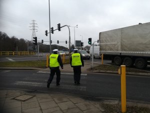 funkcjonariusze zwracający uwagę na kierujących w pobliżu przejścia dla pieszych