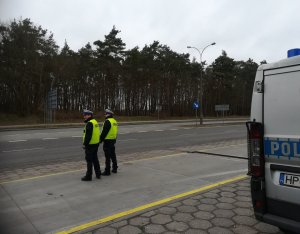 policjanci zwracający uwagę na pieszych przechodzących w miejscach niedozwolonych