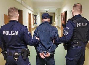 Zdjęcie pokazuje doprowadzenie osoby zatrzymanej przez policjantów