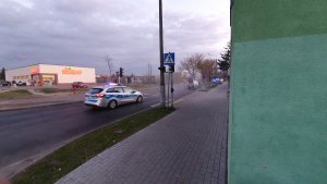 Zabezpieczenie przez policjantów ruchu drogowego maszyny dezynfekującej ulice