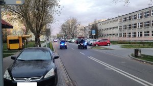 Zabezpieczenie przez policjantów ruchu drogowego maszyny dezynfekującej ulice