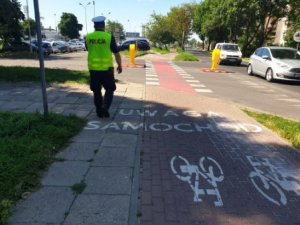 policjant ruchu drogowego idzie w kierunku przejazdu dla rowerzystów