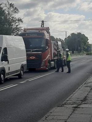 policjanci przekazują kierowcy ulotkę informacyjną