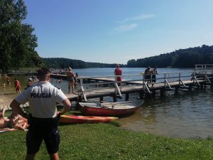 policjant obserwuje zachowania plażowiczów