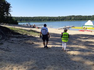 policjant i pracownik Sanepidu kontrolują plaże