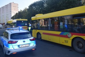 Policyjny radiowóz i stojący autobus podczas kontroli obostrzeń zgodnie z treścią informacji