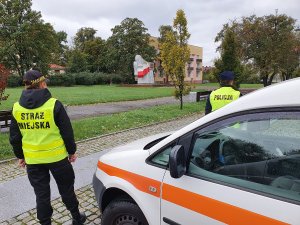 Zdjęcie z wizerunkiem policjanta i strażnika miejskiego zgodnie z treścią informacji