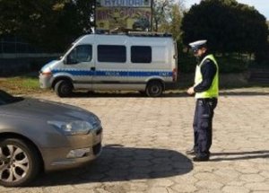 Policjant podczas sprawdzania oświetlenia pojazdu