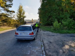 Policjant ruchu drogowego sprawdza oświetlenie pojazdu zgodnie treścią informacji