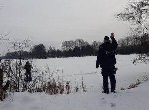 Policjant ogniwa prewencji na wodach obserwujący zamarznięte akweny zgodnie z treścią komunikatu