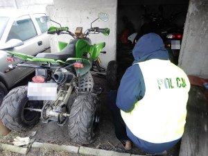 Policjant podczas czynności przy zabezpieczonych pojazdach