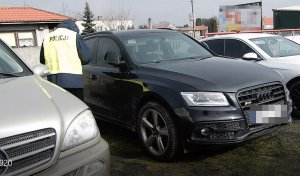 Policjant podczas czynności przy zabezpieczonych pojazdach