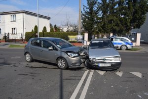 Policjanci podczas zabezpieczania miejsca wypadku drogowego zgodnie z treścią komunikatu. Uczestniczyły dwa pojazdy marki opel i skoda