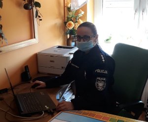 Policjantka w umundurowaniu podczas spotkania z uczniami za pomocą komputera zgodnie z treścią komunikatu