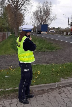 Policjant podczas działań na drogach mierzy prędkość urządzeniem