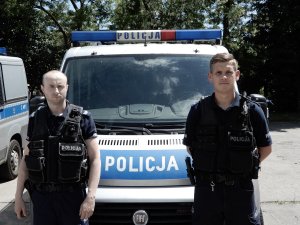 Policjanci na tle radiowozu