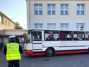 Policjant podczas kontroli autobusów szkolnych zgodnie z treścią komunikatu