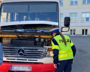 Policjant podczas kontroli autobusów szkolnych zgodnie z treścią komunikatu