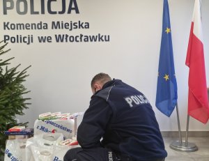 Policjanci podczas pakowania i przewożenia paczek dla dzieci zgodnie z komunikatem