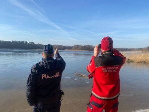 Policjant i ratownik WOPR obserwują akwen