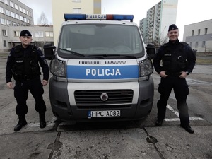 Policjanci stoją przy radiowozie