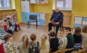 Policjant podczas czytania książki w przedszkolu.