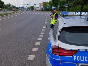 Policjant ruchu drogowego podczas mierzenia prędkości pojazdów