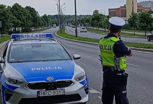 Policjant ruchu drogowego podczas mierzenia prędkości pojazdów