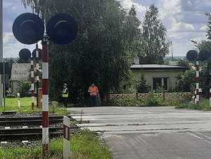 Policjant wspólnie z pracownikiem Polskich Kolei Państwowych podczas kontroli przy przejazdach kolejowych