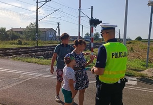 Policjant i pracownik kolei podczas działań na przejeździe kolejowym