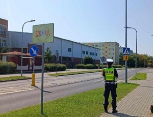 Policjant podczas kontroli oznakowania przejść przed szkołami