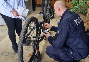 Policjanci podczas znakowania rowerów w komendzie