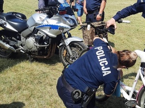 Policjanci podczas pikniku znakowanie rowerów i pokaz sprzętu służbowego