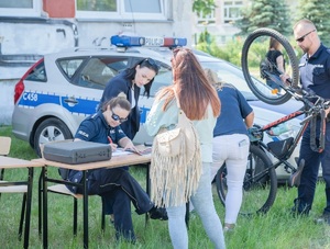 Policjanci podczas znakowania rowerów na festynie przy szkole podstawowej