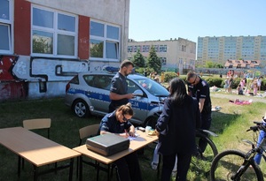 Policjanci podczas znakowania rowerów na festynie przy szkole podstawowej