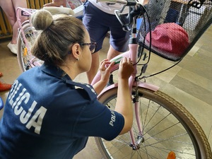 Policjantka podczas znakowani rowerów na terenie komendy