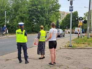 Policjanci i pracownicy kolei podczas działań przy przejeździe kolejowym