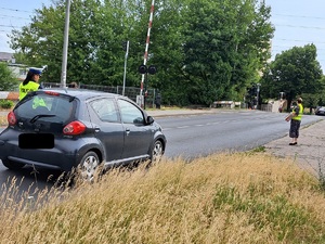 Policjanci i pracownicy kolei podczas działań przy przejeździe kolejowym